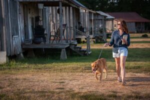 A woman walking her dog through Tallahatchie Flats.